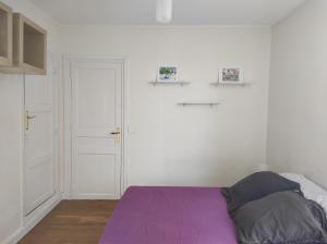 a bedroom with a purple bed and a white wall at Maison cosy & épurée avec jardin et wifi - Orly Rungis in Orly