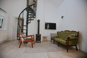 a living room with a green couch and a staircase at Domek przy winnicy 