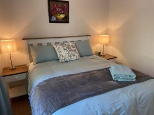 a bedroom with a bed with two lamps on both sides at Peartree Cottage in Hogsback