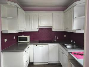 a white kitchen with white cabinets and a sink at Maison cosy & épurée avec jardin et wifi - Orly Rungis in Orly