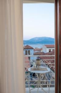 een tafel en stoelen op een balkon met uitzicht bij Leone suites in Nafpaktos