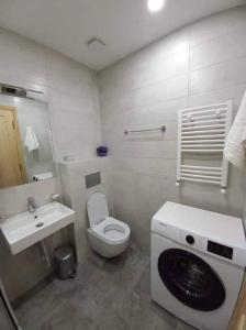 een badkamer met een toilet, een wastafel en een wasmachine bij Redco"The Valley Residence & Spa" Bakuriani in Bakuriani