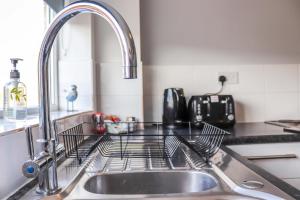 a kitchen sink with a dish drying rack on it at Seaside Retreat - Modern - 2 BR - SA - By the Sea in Woodhorn