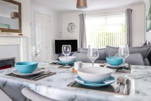 a dining room table with plates and bowls and wine glasses at Seaside Retreat - Modern - 2 BR - SA - By the Sea in Woodhorn