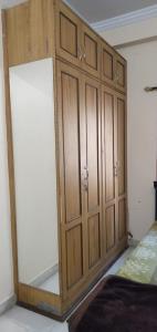 Srinivas Nilayam في حيدر أباد: خزانة خشبية كبيرة في غرفة مع سرير