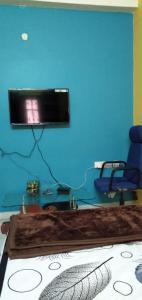 Srinivas Nilayam في حيدر أباد: غرفة بها كرسيين وتلفزيون على جدار ازرق