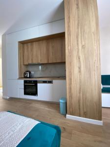 a kitchen with white walls and a wooden door at Star Apartament Gjiri lalzit, Lura 2 in Lalzit Bay