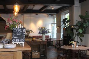 a restaurant with tables and chairs and a chalkboard at Boutique Hotel Weesp in Weesp