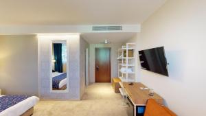 um quarto de hotel com um quarto com uma cama e uma secretária em EPIGRAPH Design Hotel em Tbilisi mais 44 fotografias