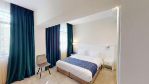 um quarto com uma cama grande e um espelho em EPIGRAPH Design Hotel em Tbilisi