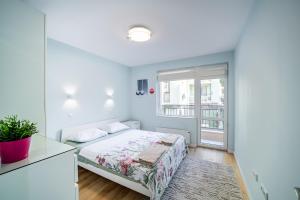 a bedroom with a bed and a window at Colibri Central Apartment in Varna City