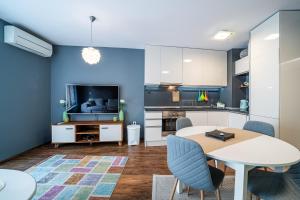 a living room with a table and a kitchen at Colibri Central Apartment in Varna City