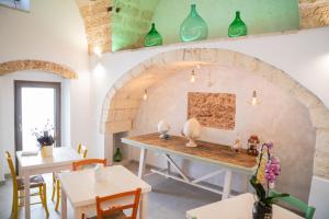Corte Janca في Montesano Salentino: غرفة مع طاولة مع مزهريات على الحائط