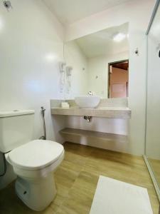 uma casa de banho com um WC branco e um lavatório. em Pousada Recanto da Pedra em Iriri