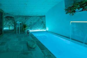 a swimming pool with blue lighting in a house at Corte Janca in Montesano Salentino