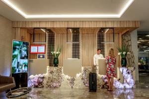 a man and a woman standing in a lobby at Ramada by Wyndham Ramnicu Valcea in Râmnicu Vâlcea