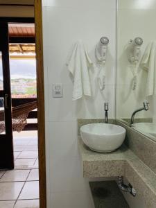 uma casa de banho com um lavatório branco e um espelho. em Pousada Recanto da Pedra em Iriri