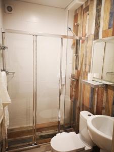 uma casa de banho com um chuveiro, um WC e um lavatório. em Гостевой дом Discovery em Almaty