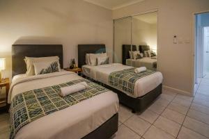 a hotel room with two beds and a mirror at ZEN HIDEAWAY COZY 2-BR/2-BA Modern Unit in Alawa in Casuarina