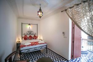 a bedroom with a bed and a chandelier at Dar Hafsa in Fez