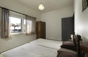 哈拉奇的住宿－Georgias Apartments，一间卧室设有一张大床和一个窗户。