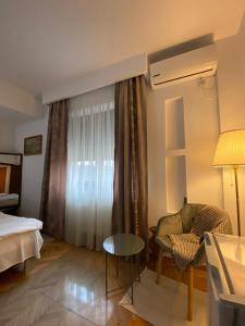 una stanza d'albergo con un letto, una sedia e una finestra di Dinamic Studio Old Town a Bucarest