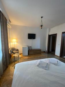 una camera da letto con un letto bianco e una televisione di Dinamic Studio Old Town a Bucarest