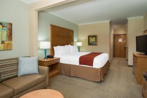 a hotel room with a large bed and a couch at Holiday Inn Express Hotel & Suites Santa Clara - Silicon Valley, an IHG Hotel in Santa Clara