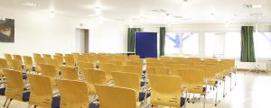 una sala de conferencias vacía con sillas amarillas. en Jugendherberge Hannover, en Hannover