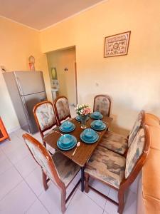 a dining room table with chairs and a wooden table with plates at Alicia's appartementen 