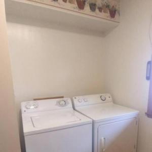 a white laundry room with a washer and dryer at Brett's on the Lake in Durand
