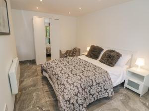 a bedroom with a large white bed and a table at Hollywell Cottage in Lichfield