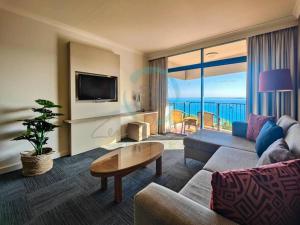 una sala de estar con un sofá y una mesa en ZEN88 ESPLANADE: 1-BR Top Floor Ocean View Suite, en Darwin