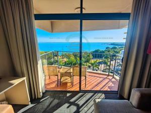 a room with a balcony with a view of the ocean at ZEN88 ESPLANADE: 1-BR Top Floor Ocean View Suite in Darwin