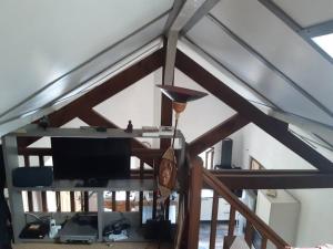 Pokój z sufitem, telewizorem i stołem w obiekcie Gîte de la P'tite Rainette w mieście Grosne