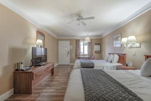 a hotel room with two beds and a flat screen tv at Shasta Pines Motel & Suites in Burney