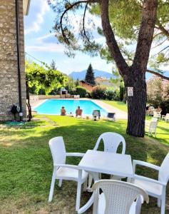 un tavolo e sedie in un cortile con piscina di Paradise Apartment Malcesine a Malcesine