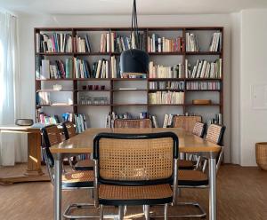 a dining room with a table and chairs in front of a book shelf at kirchgässlein in Dinkelsbühl