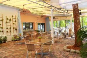 un patio avec des tables et des chaises dans un restaurant dans l'établissement Victoria Park Hotel, à Fort Lauderdale