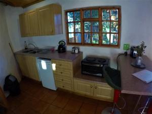 a small kitchen with a sink and a refrigerator at Gryffin Cottage at Hogwarts Forest in Hogsback +12 photos