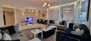 ein Wohnzimmer mit Sofas und einem TV in der Unterkunft شقة مطلة على البحر والفورمولا ببرج المسارات in Dschidda