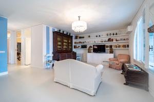 a living room with a white chair and a couch at Casa Azzurra in Messina