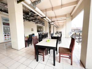 a dining area with tables and chairs in a building at OYO Capital O 91631 M-square Apartement in Bandung