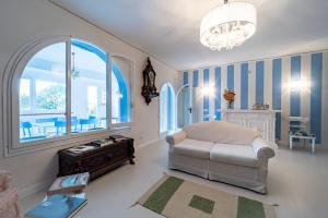 a living room with a chair and a chandelier at Casa Azzurra in Messina