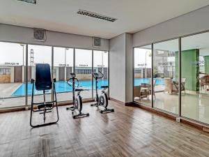a gym with exercise bikes and a swimming pool at OYO Capital O 91631 M-square Apartement in Bandung