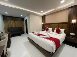 a bedroom with a large bed and a flat screen tv at THE IMPERIAL HOTEL & Spa in Gangtok