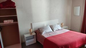 1 dormitorio con 1 cama con manta roja en Cabañas el Rombo, en Puerto Montt