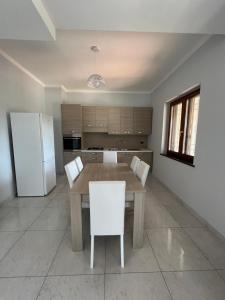 a kitchen with a wooden table and a white refrigerator at Patricia’s House in Striano +12 photos