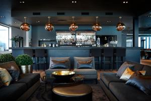 Im Hintergrund eine Lobby mit Sofas und einer Bar. in der Unterkunft Hotel Frøya in Sistranda