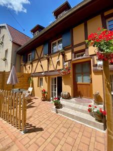 uma casa com uma cerca e flores à frente dela em Coeur d'Alsace Colmar Vignobles Ouest avec terrasses em Wintzenheim